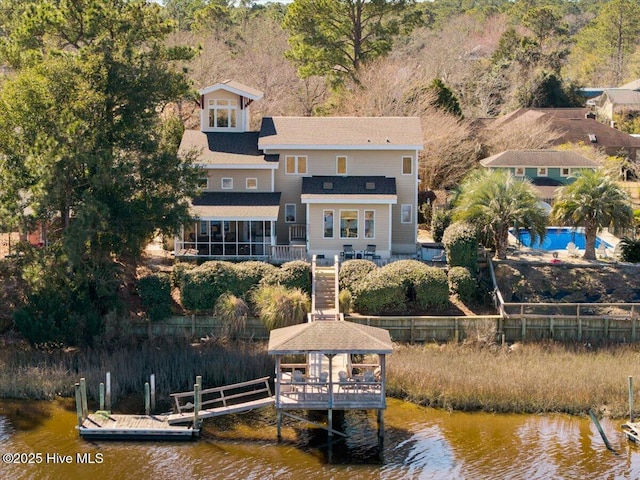 dock area with a water view, fence, and a gazebo