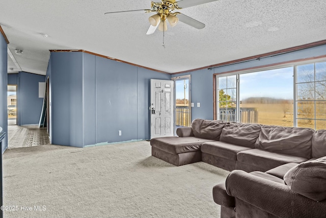 carpeted living room featuring ceiling fan, crown molding, and a textured ceiling