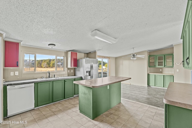 kitchen featuring sink, dishwasher, plenty of natural light, stainless steel refrigerator with ice dispenser, and a kitchen island