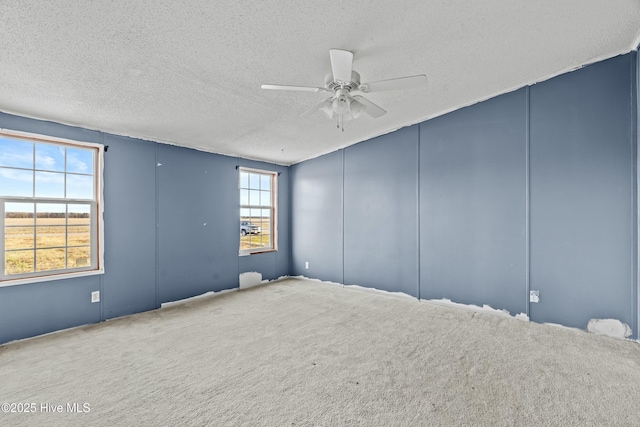 unfurnished room featuring ceiling fan, carpet floors, and a textured ceiling