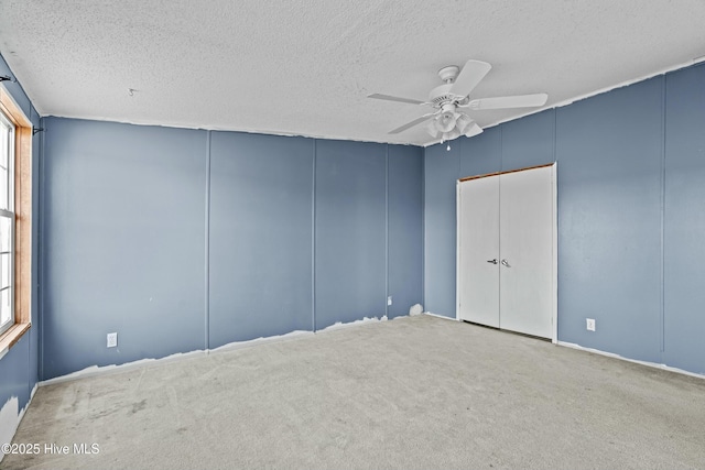 spare room with ceiling fan, carpet floors, and a textured ceiling