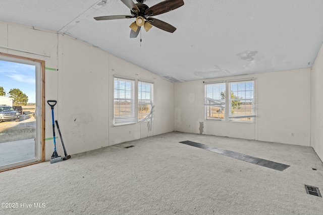 carpeted spare room with ceiling fan and vaulted ceiling