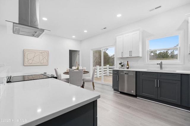 kitchen featuring white cabinets, dishwasher, island exhaust hood, light countertops, and a sink