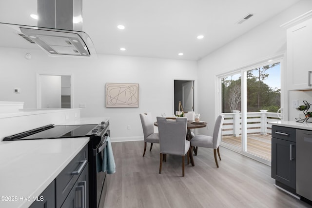 dining area featuring light wood-type flooring, baseboards, visible vents, and recessed lighting