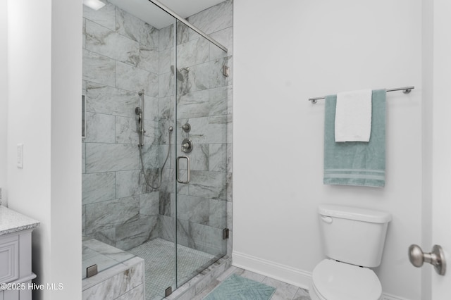 full bathroom featuring toilet, a shower stall, baseboards, and vanity