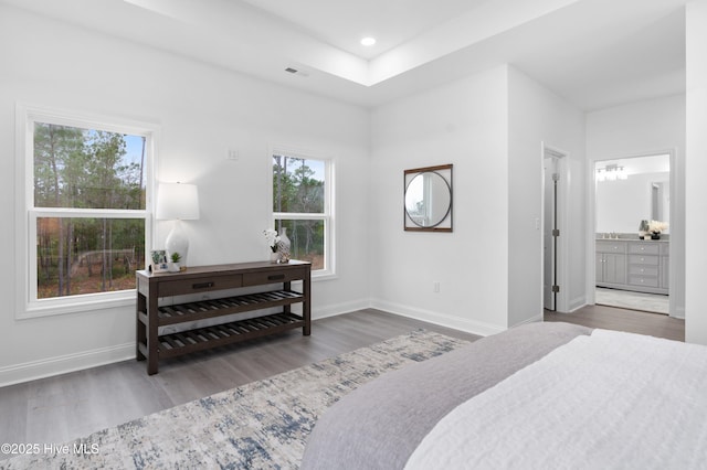 bedroom with visible vents, baseboards, ensuite bath, wood finished floors, and recessed lighting