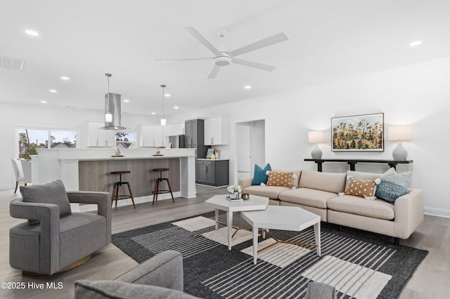 living room with ceiling fan, recessed lighting, wood finished floors, visible vents, and baseboards