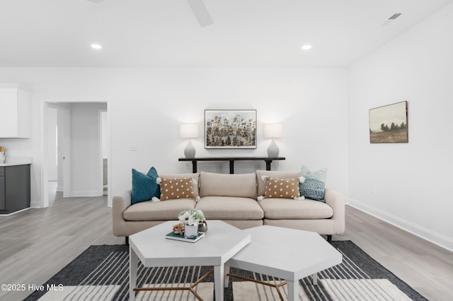 living area featuring light wood-type flooring, baseboards, and recessed lighting