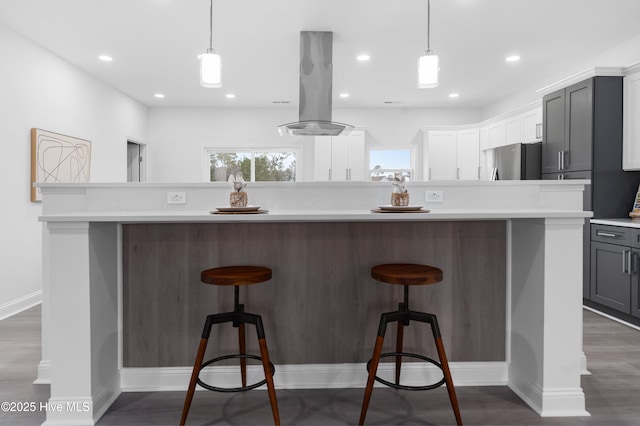 kitchen featuring a large island, freestanding refrigerator, island exhaust hood, gray cabinets, and light countertops