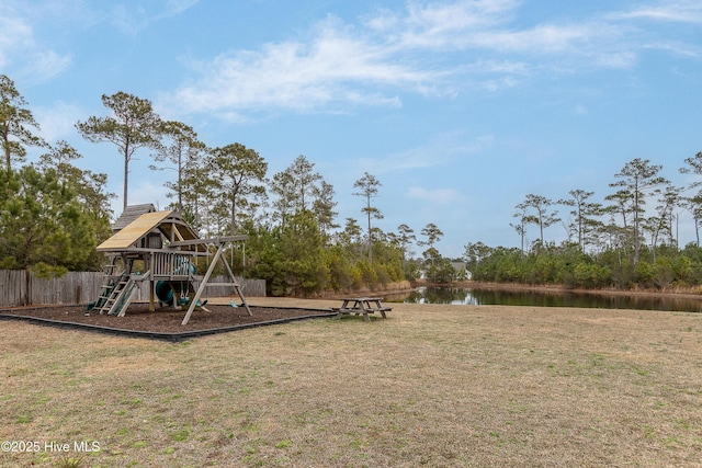 community playground with a water view, fence, and a yard