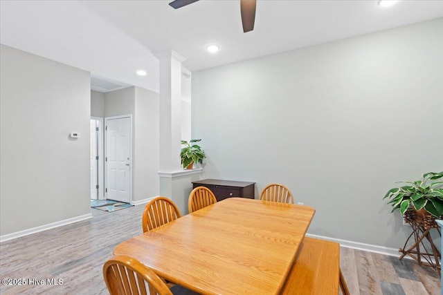 dining room featuring ceiling fan, wood-type flooring, and decorative columns