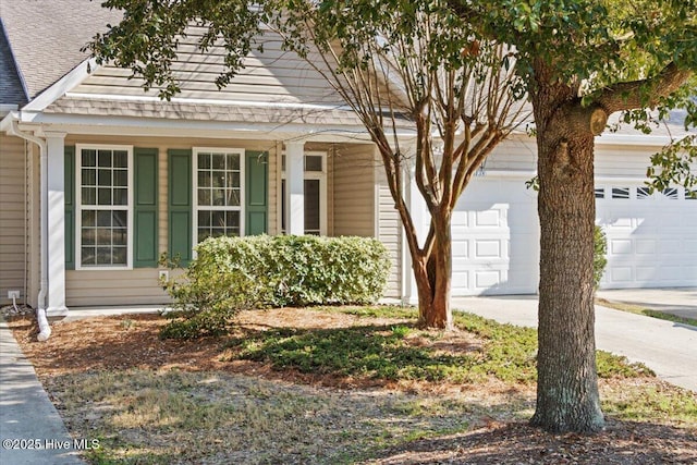 view of front of home featuring a garage, driveway, and a shingled roof