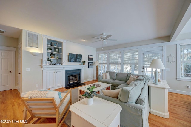 living room with ceiling fan, a healthy amount of sunlight, and light wood-type flooring