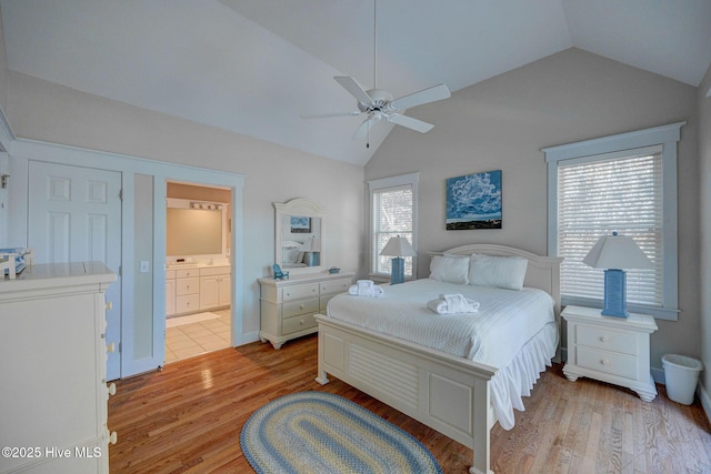 bedroom featuring vaulted ceiling, connected bathroom, ceiling fan, and light hardwood / wood-style floors