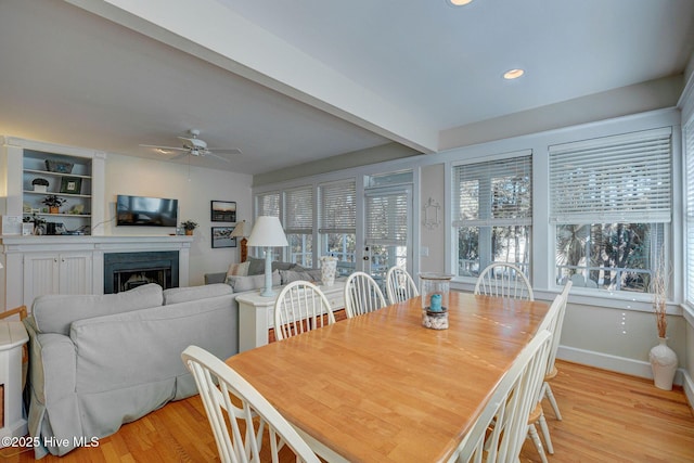 dining area with beam ceiling, light hardwood / wood-style floors, and ceiling fan