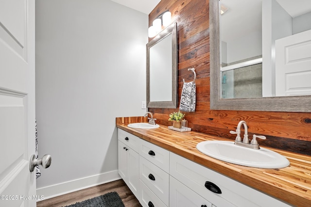 bathroom with hardwood / wood-style flooring, vanity, and an enclosed shower