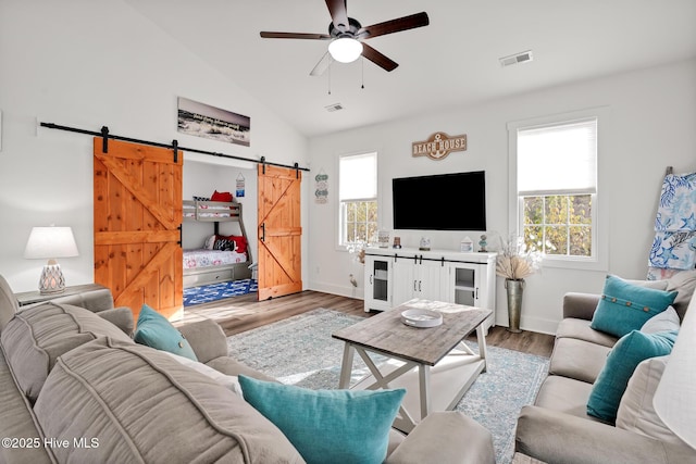 living room featuring wine cooler, vaulted ceiling, hardwood / wood-style flooring, ceiling fan, and a barn door