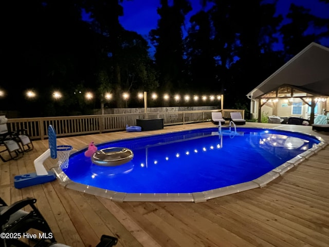 pool at twilight featuring a deck