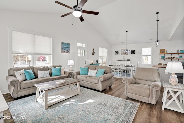 living room with ceiling fan, plenty of natural light, dark hardwood / wood-style flooring, and high vaulted ceiling