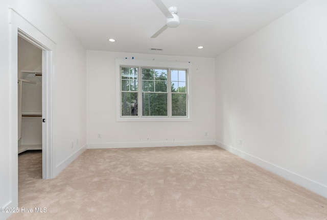 unfurnished room with ceiling fan and light colored carpet