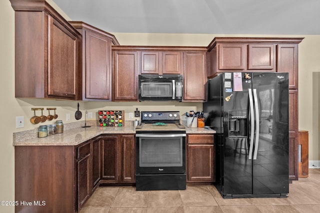 kitchen with light stone counters, light tile patterned floors, and black appliances