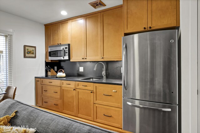 kitchen with sink, decorative backsplash, and stainless steel appliances