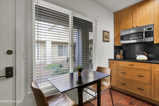 dining room featuring a healthy amount of sunlight and dark wood-type flooring