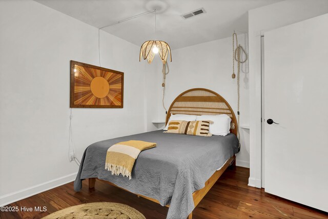 bedroom with dark hardwood / wood-style floors