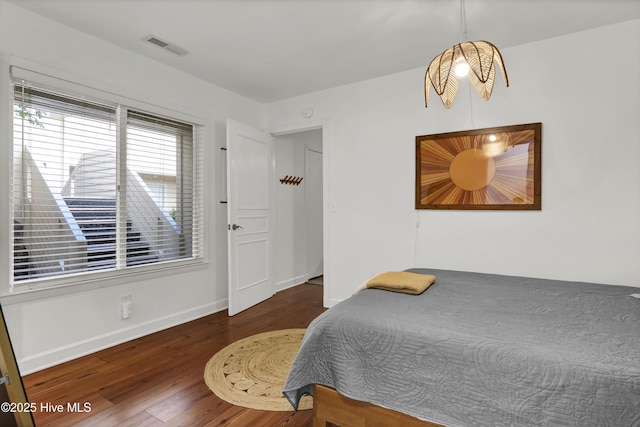 bedroom with dark hardwood / wood-style flooring