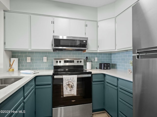 kitchen featuring tasteful backsplash, appliances with stainless steel finishes, and white cabinets