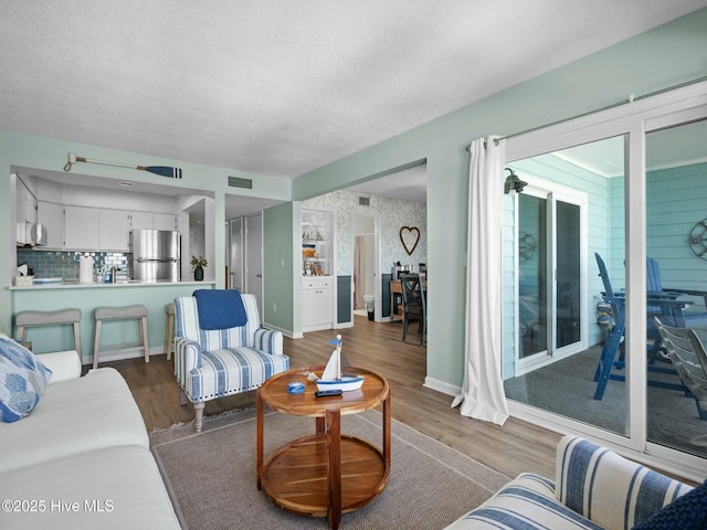 living room featuring light hardwood / wood-style flooring and a textured ceiling