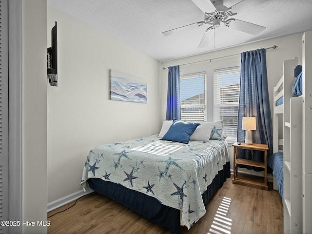 bedroom with ceiling fan, hardwood / wood-style flooring, and a textured ceiling