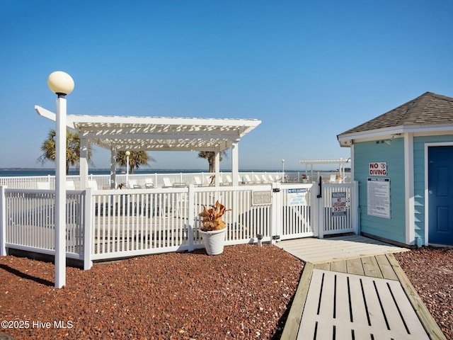 exterior space featuring a water view and a pergola