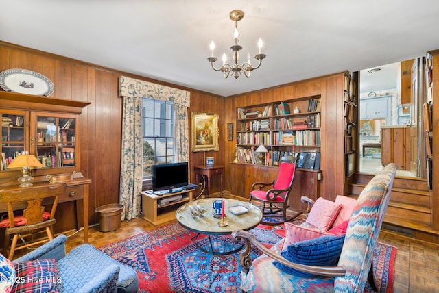 sitting room with parquet flooring, wooden walls, and an inviting chandelier