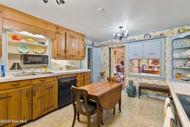 kitchen featuring decorative light fixtures, sink, tile counters, black appliances, and an inviting chandelier