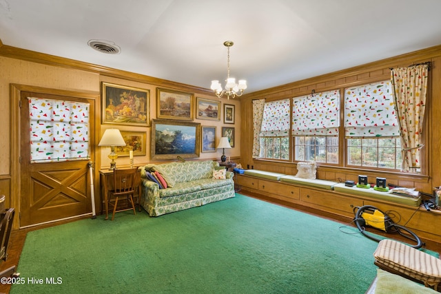 sitting room with crown molding, carpet flooring, and an inviting chandelier