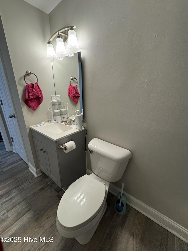 bathroom with wood-type flooring, toilet, and vanity