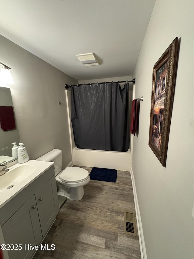 full bathroom with shower / tub combo with curtain, vanity, hardwood / wood-style flooring, and toilet