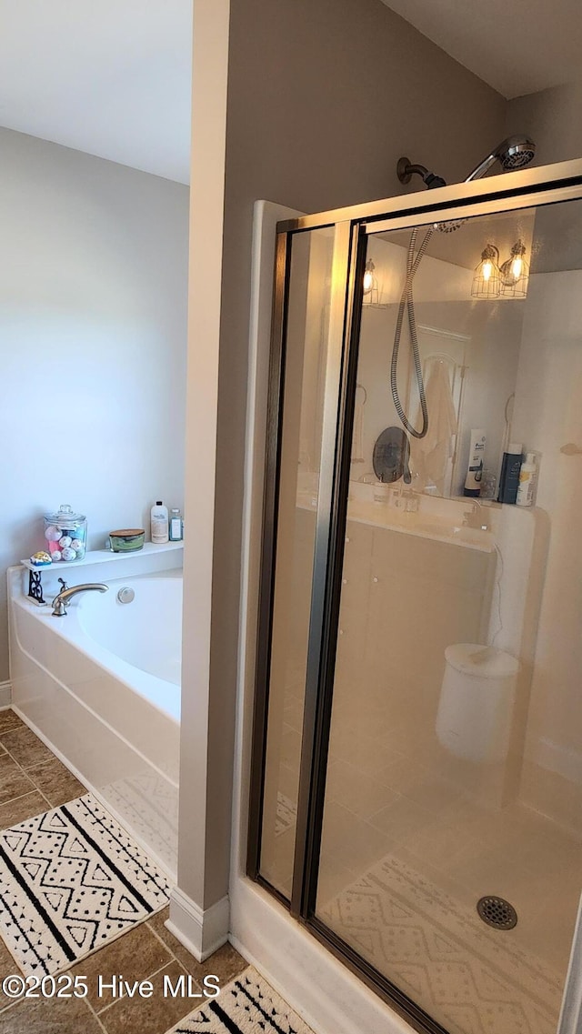 bathroom featuring tile patterned flooring and separate shower and tub