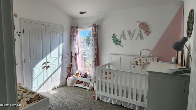 carpeted bedroom featuring a crib, vaulted ceiling, and a closet