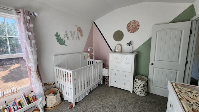 carpeted bedroom with multiple windows, a crib, and vaulted ceiling