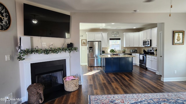 kitchen featuring a kitchen island, dark hardwood / wood-style floors, white cabinets, and appliances with stainless steel finishes