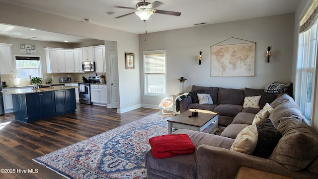 living room featuring ceiling fan and dark hardwood / wood-style flooring