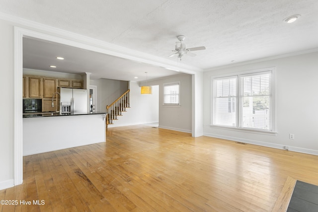 unfurnished living room featuring crown molding, a textured ceiling, ceiling fan, and light hardwood / wood-style floors