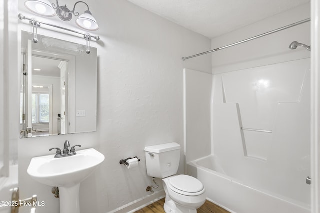 full bathroom featuring hardwood / wood-style flooring, shower / tub combination, sink, and toilet