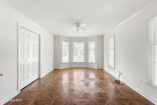 empty room with ornamental molding, dark parquet floors, and a textured ceiling