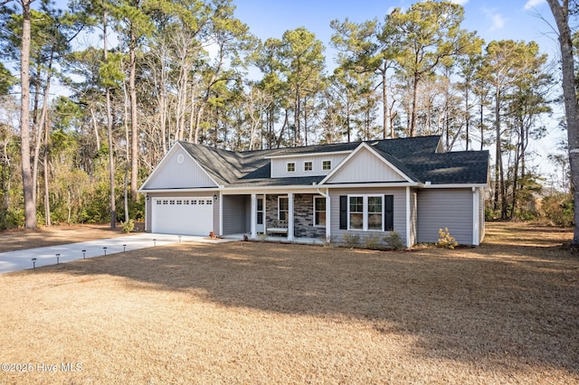 view of front of property with covered porch, a garage, a lawn, roof with shingles, and driveway