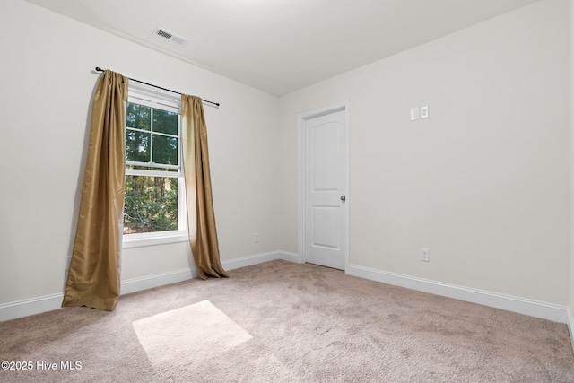 spare room featuring light carpet