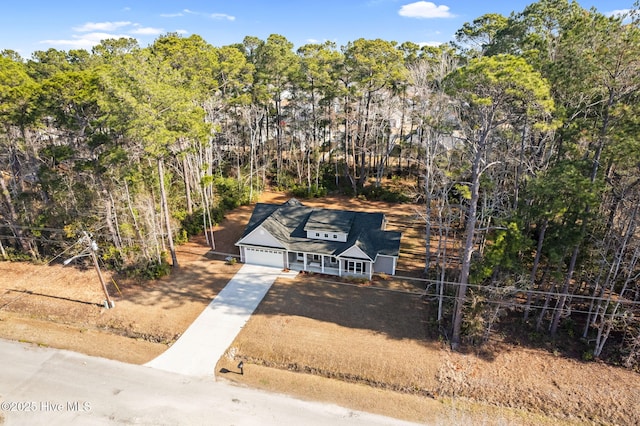 drone / aerial view featuring a wooded view