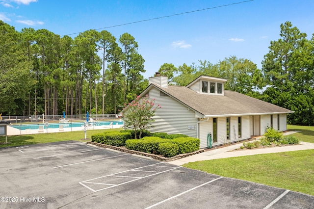 view of front facade with a fenced in pool and a front yard